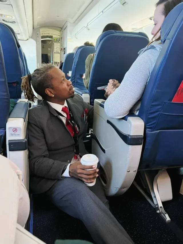 Comissário de bordo segura mão de passageira em voo